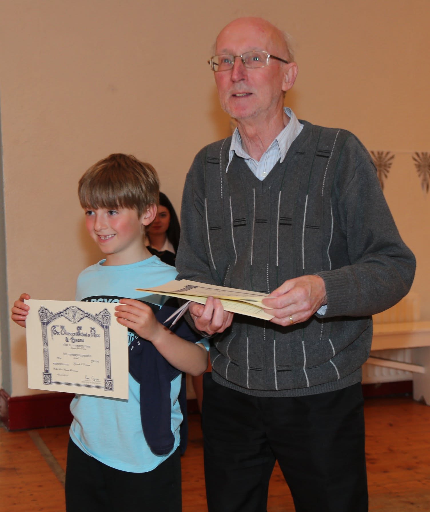 Gabe Maher presenting a certificate to a student